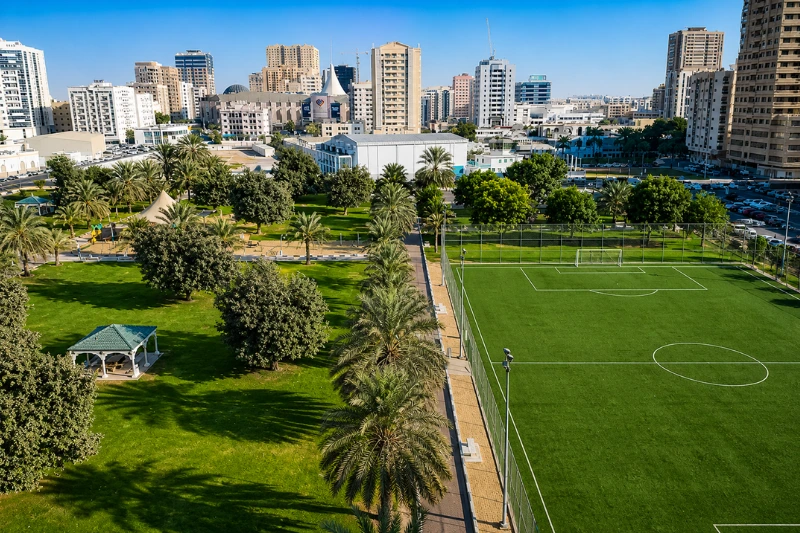 Aerial view of Al Mahatta Park with green lawns and football field in Sharjah
