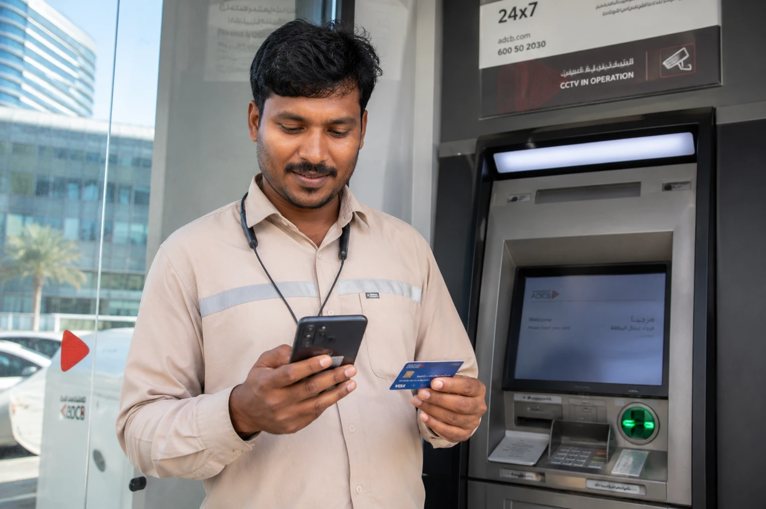 employee holding a salary card near an ATM or checking salary notification on phone