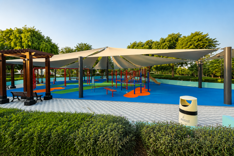 Children's playground with shaded play area at Al Quoz Pond Park in Dubai