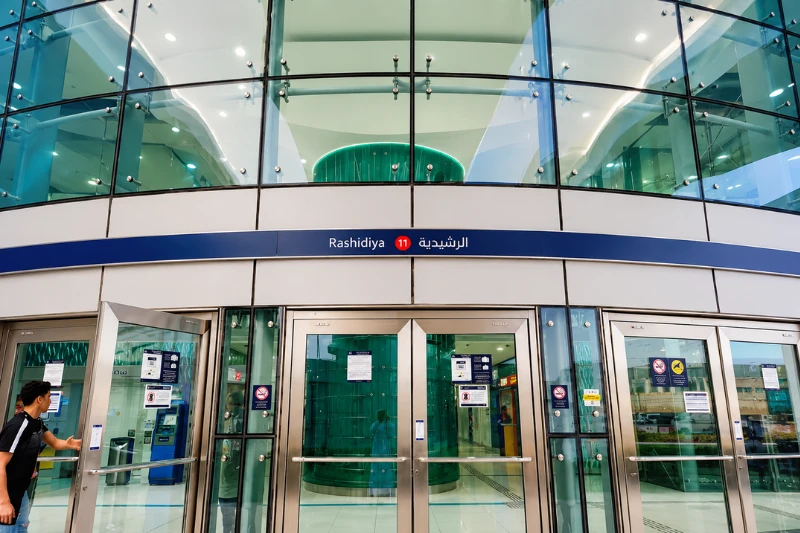 Entrance of Rashidiya Metro Station in Dubai with station signage above the doors