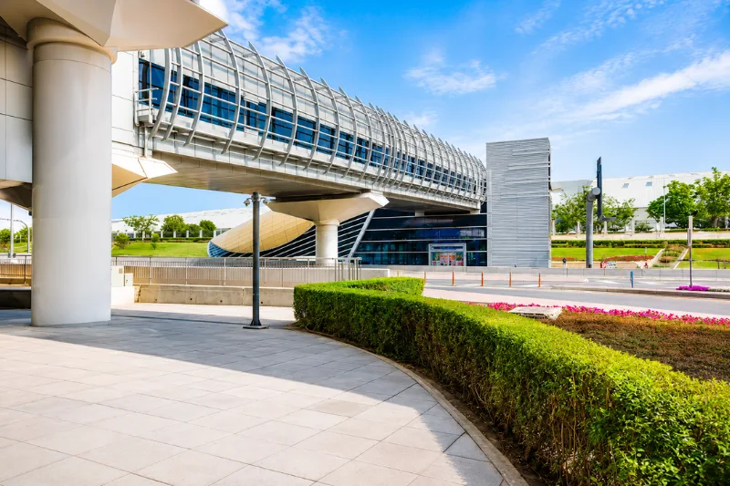 Exterior view of Rashidiya Metro Station with elevated pedestrian walkway and landscaped surroundings