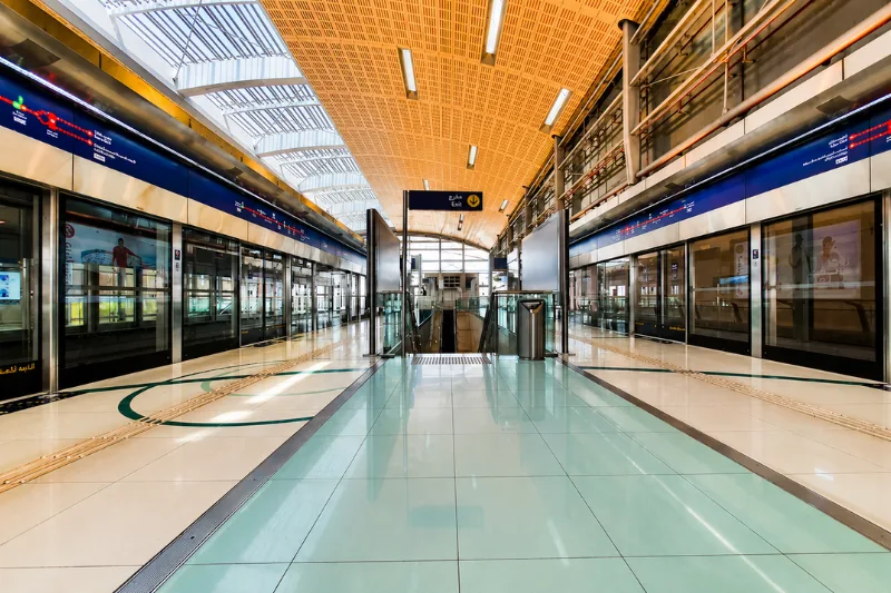 Interior platform view of Rashidiya Metro Station with Dubai Metro trains on both sides