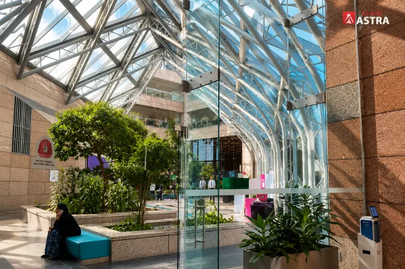 Modern atrium interior of Sheikh Khalifa Energy Complex with glass architecture and indoor greenery