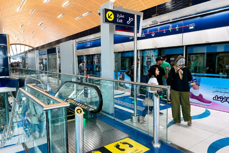 Passengers waiting at Dubai Internet City Metro Station platform near the exit