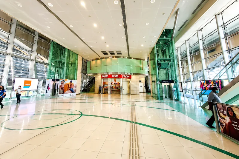 Spacious concourse area inside Rashidiya Metro Station with retail shops and passenger facilities