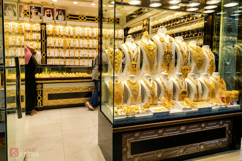 Gold jewellery displays inside a Dubai Gold Souk shop featuring necklaces, bangles, and traditional bridal sets