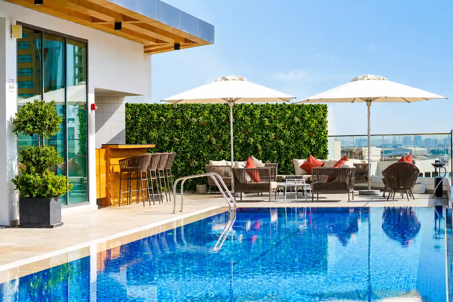 Modern hotel pool and outdoor lounge area at Jaddaf Waterfront with relaxing waterfront views