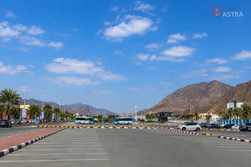 Parking area and surrounding roads near Fujairah Bus Station with mountain views and local bus access