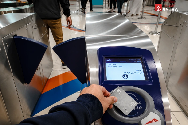 Passenger tapping a Nol Card at the fare gate inside Al Rigga Metro Station in Dubai