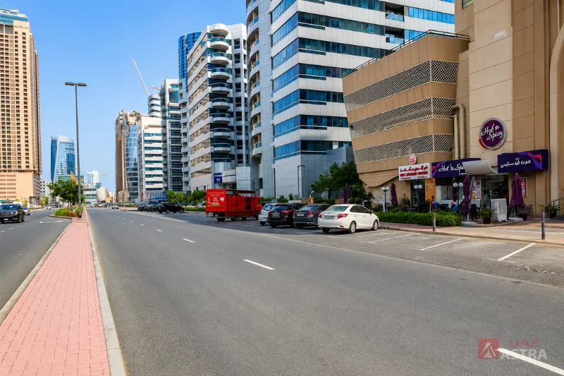 Street view near Al Shaiba Tower A in Barsha Heights, Dubai, with nearby shops and parking