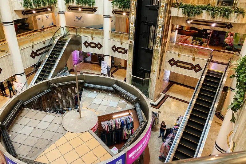 Interior escalators and retail shops at Al Bakhit Center