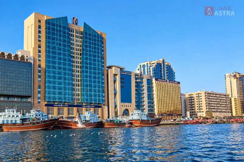 Traditional boats on Dubai Creek near Al Sabkha Marine Station and Deira waterfront buildings