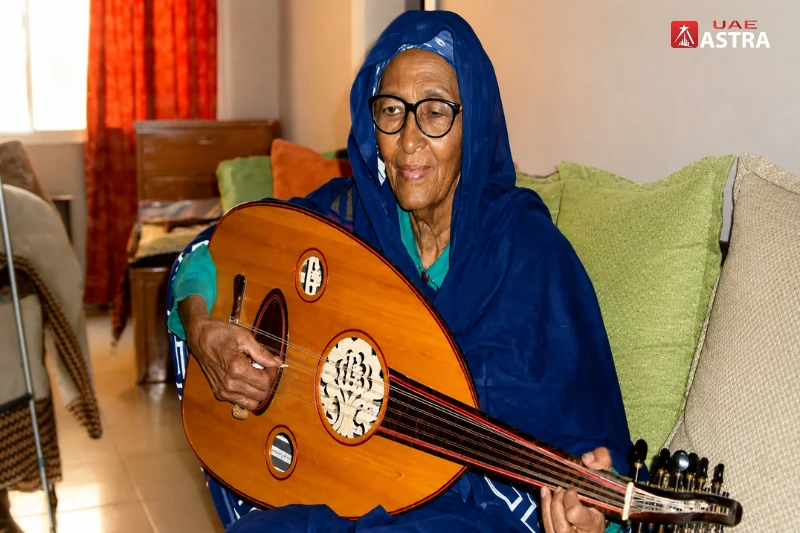 Asma Hamza playing the oud during a traditional Sudanese music session indoors