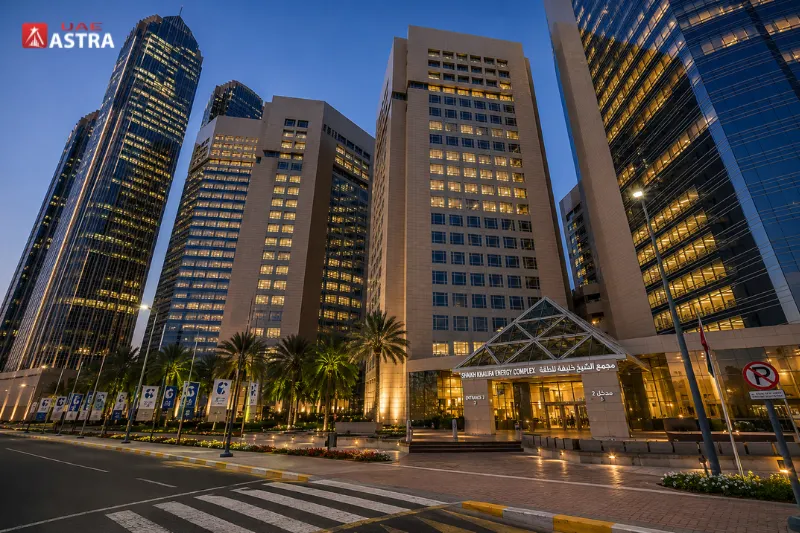 Sheikh Khalifa Energy Complex office towers in Abu Dhabi at dusk with illuminated buildings and landscaped entrance
