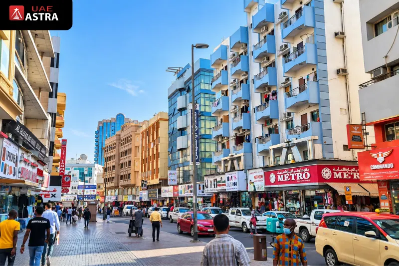 Busy commercial street in Al Sabkha, Deira, surrounded by shops, residential buildings and traditional market activity