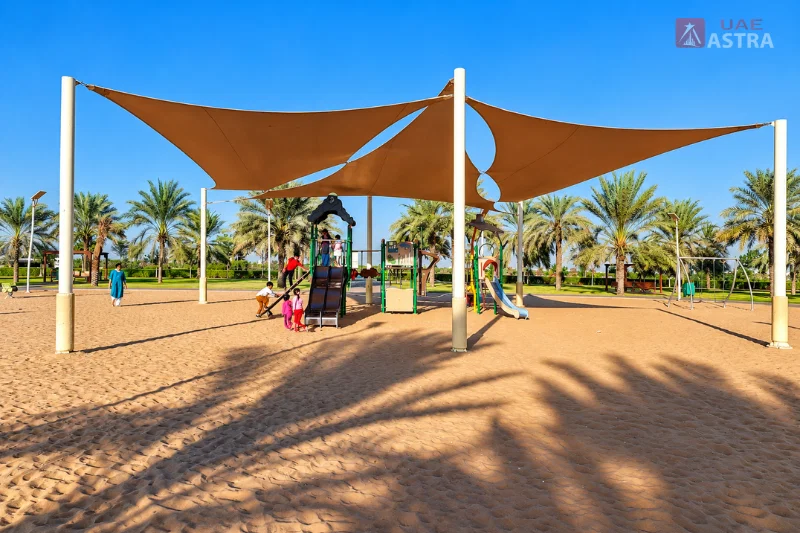 Al Safia Park childrens playground with shaded slides and swings