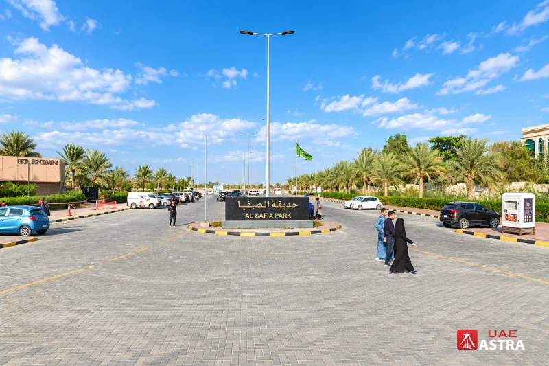 Al Safia Park entrance in Ajman with palm trees and parking area