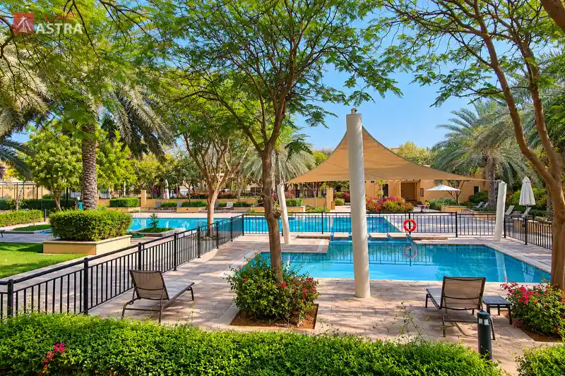 Arabian Ranches Dubai community swimming pool with shaded seating and landscaped gardens