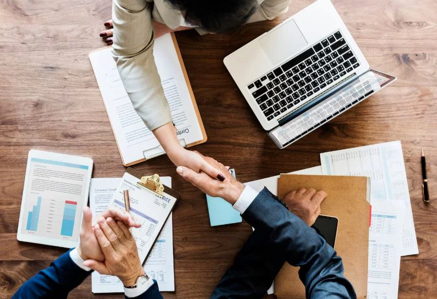 Business professionals shaking hands during a company meeting