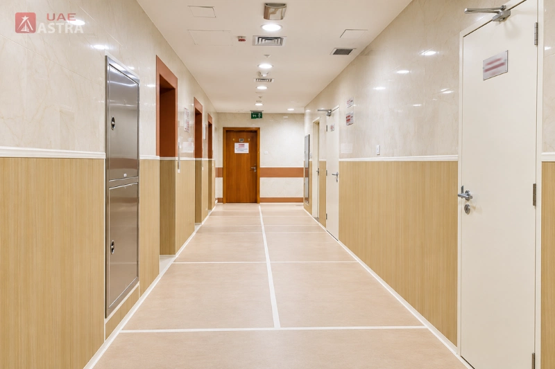 Interior corridor in Capital Golden Tower, Dubai, with tiled walls, office doors and ceiling lighting