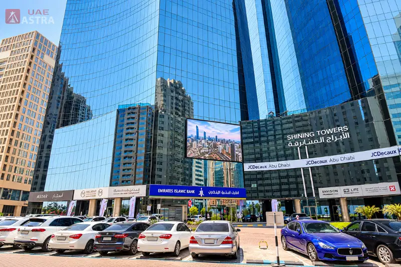 Shining Towers exterior with parking area and retail shops